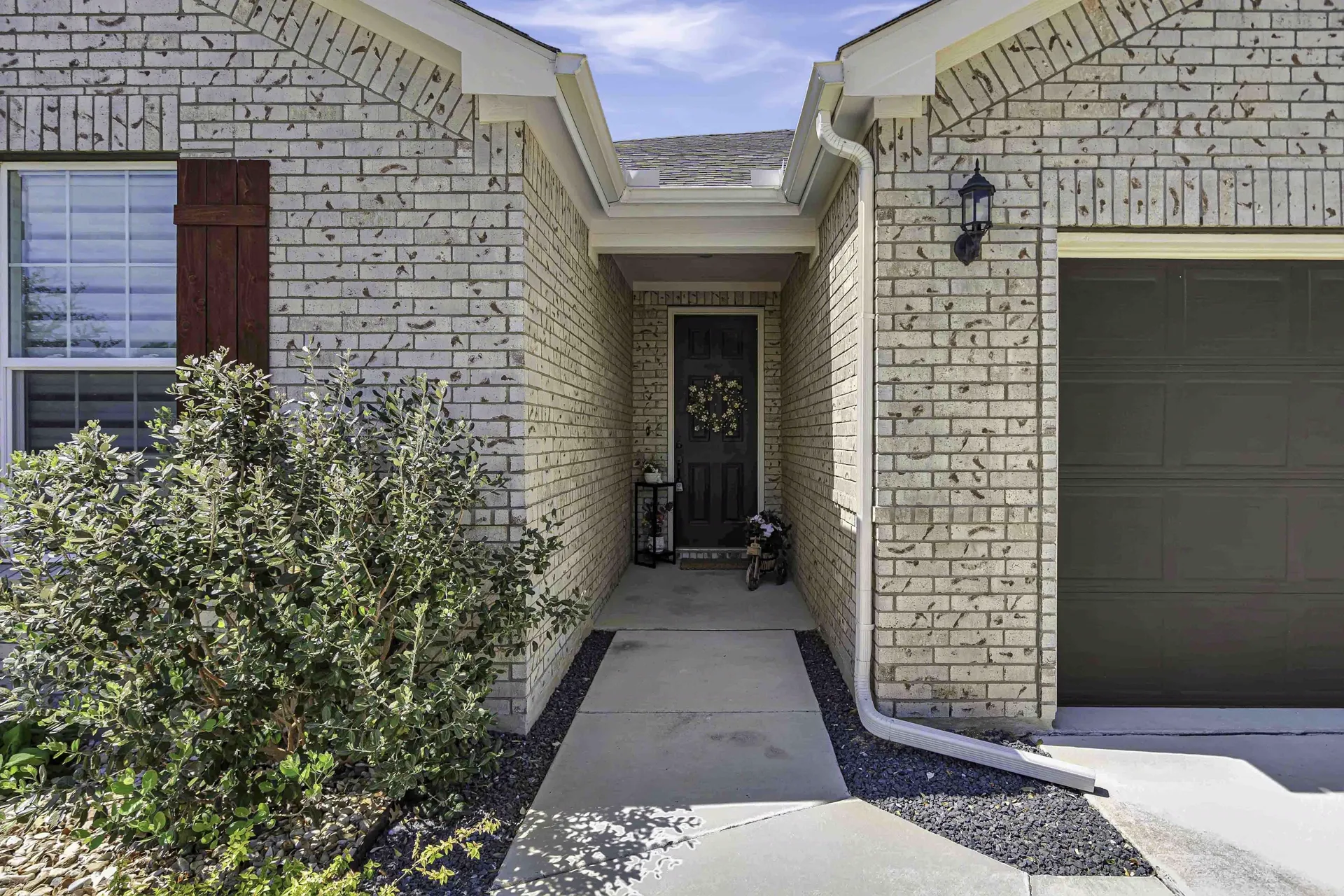 Front entry approach with stone pillars and covered porch