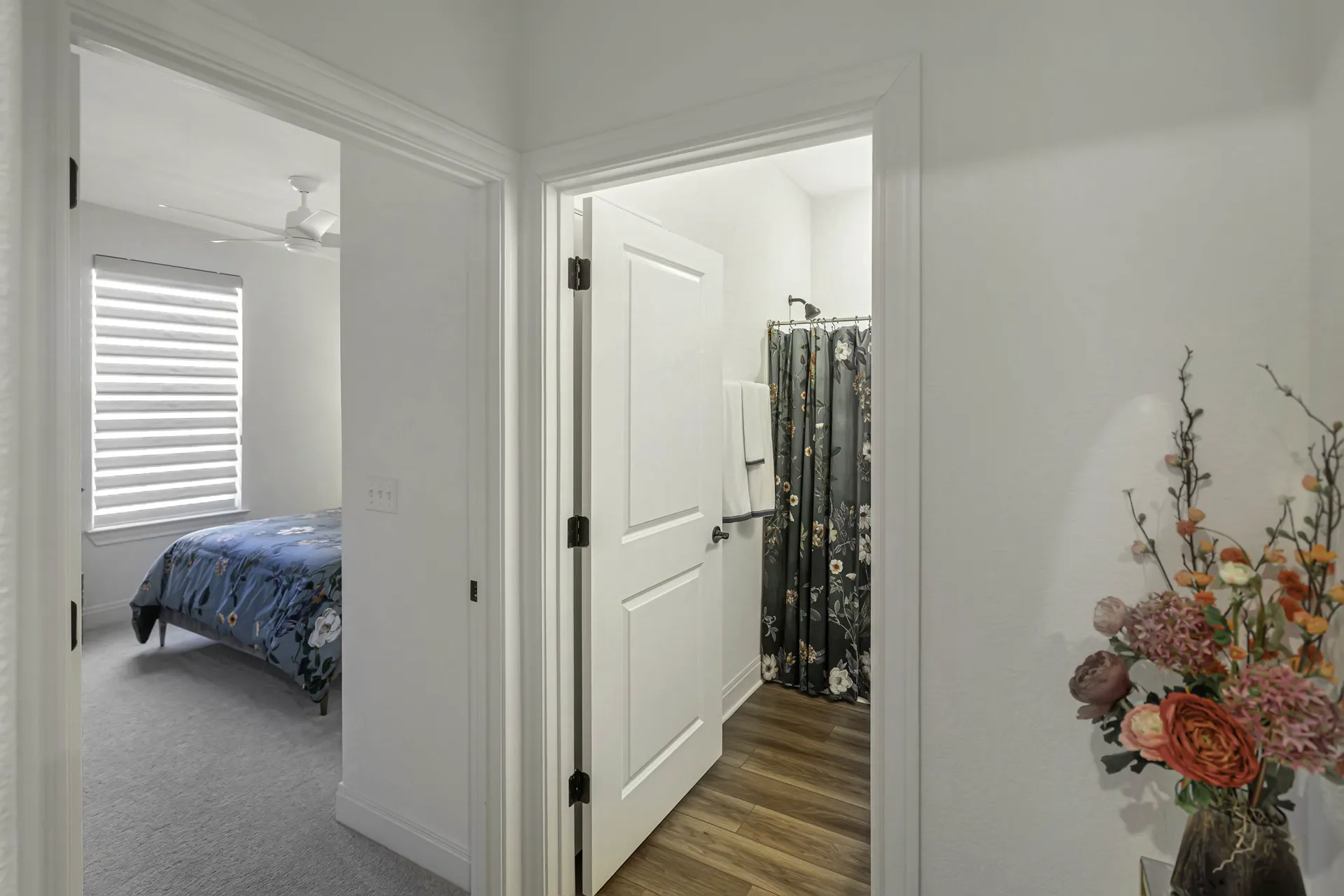 Guest bedroom with blue bedding, art and hardwood floors