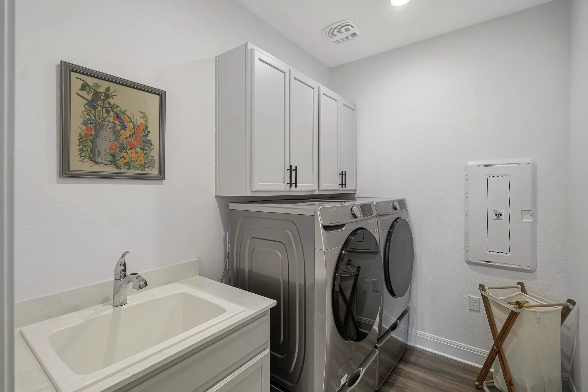 Laundry room with washer, dryer, utility sink and cabinetry