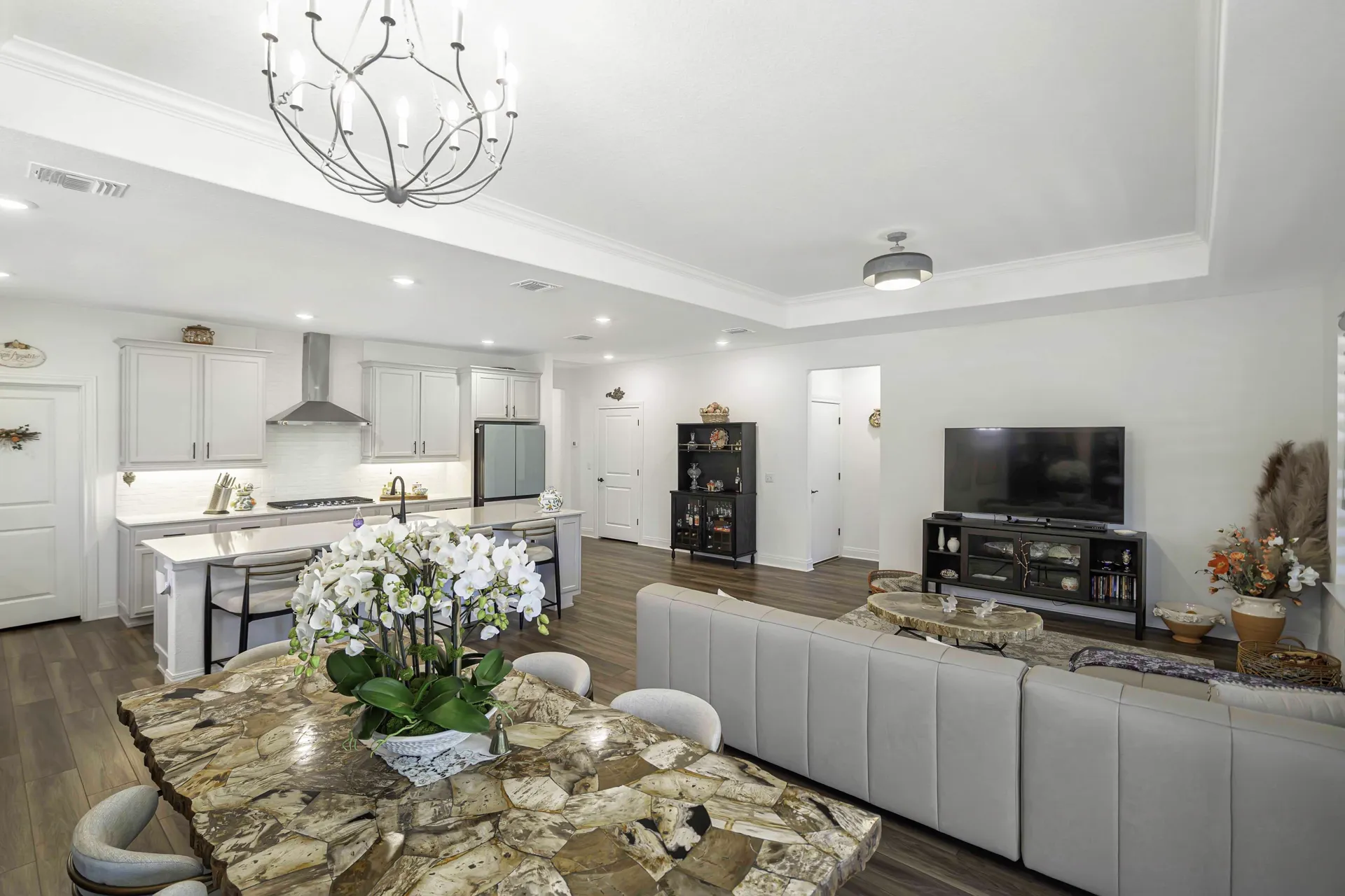 Living area with stone accent table and open kitchen beyond
