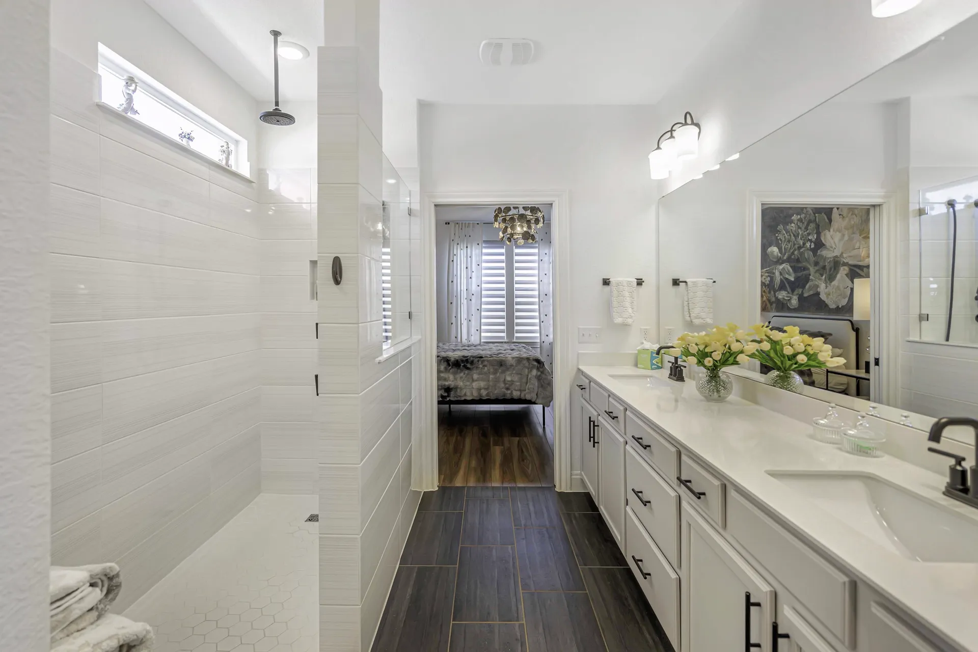 Bathroom with walk-in shower, dual vanity and view to bedroom